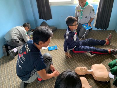 現地の小学生たちにミニアン（CPR訓練人形）を使って心肺蘇生法を教えます。