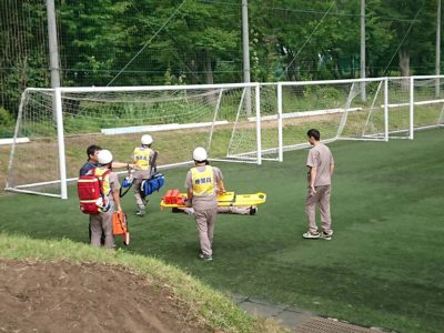 スポーツ現場における救急対応を想定した訓練は、現場をリアルに再現して行っています。